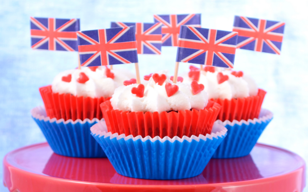 Cupcakes on a plate with Union flags on top, decorated in red, white and blue