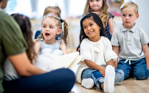 A group of young children sitting on the floor listening to stories