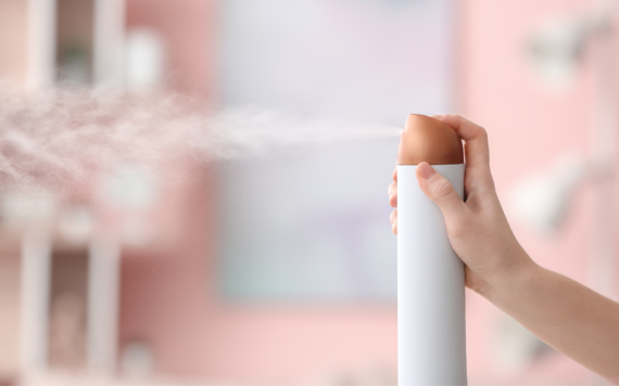 A hand spraying an air freshener