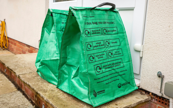 Two green recycling bags at the doorsteps