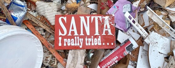 close up of a pile of fly-tipped waste with sign saying "Santa - I really tried"