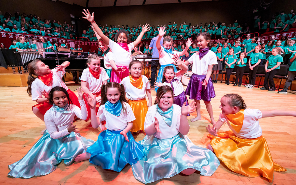 A group of children during a dance routine in front of a crowd at the Hexagon