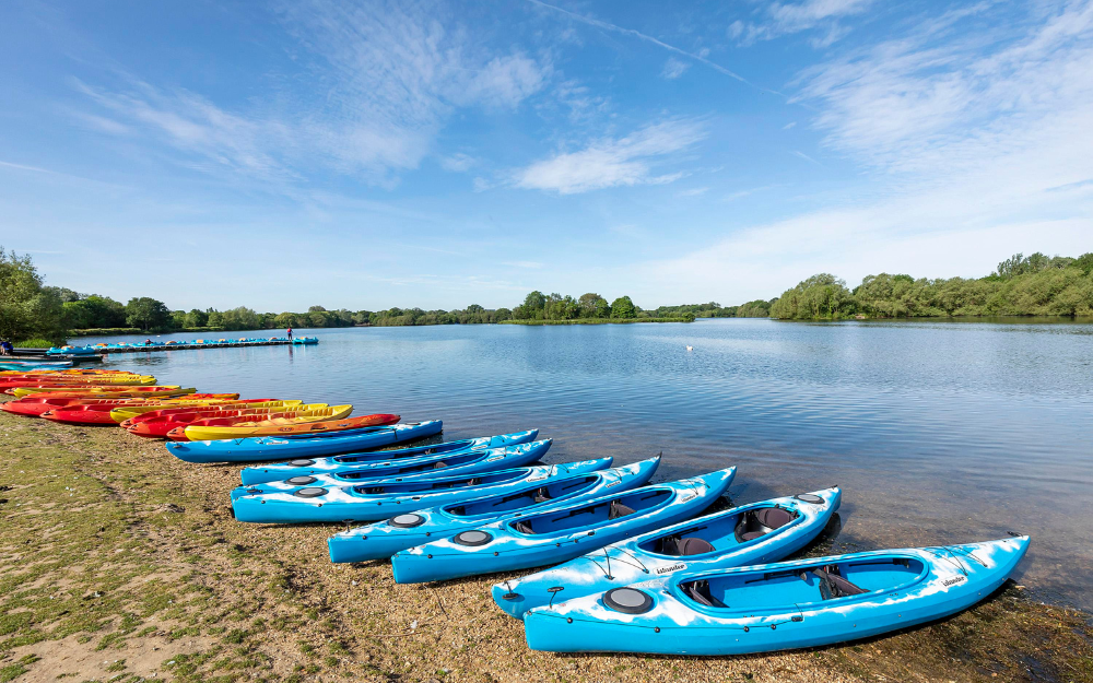 Canoes on the shore by the lake at Dinton Pastures Country Park