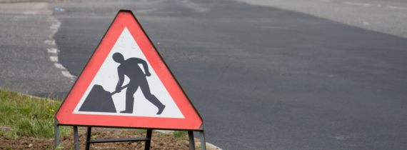 A close-up of a roadworks sign at the side of a road