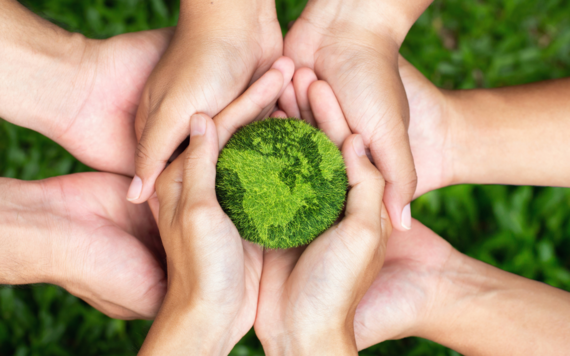 Hands holding a green Earth