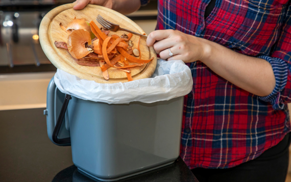 Kitchen scraps being put into a food waste caddy