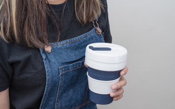 Lady holding a reusable coffee cup