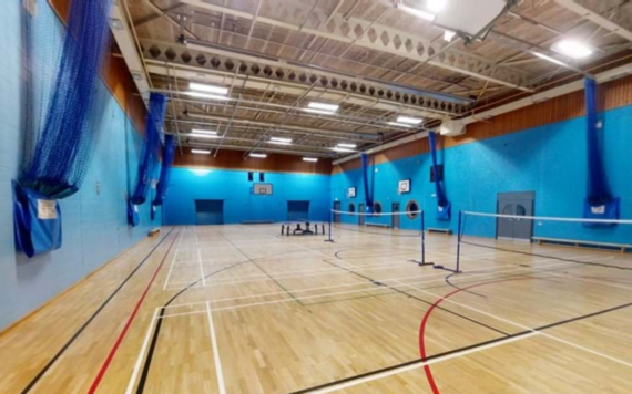 photo of the interior of the leisure centre showing a large open hall with floor markings for sports