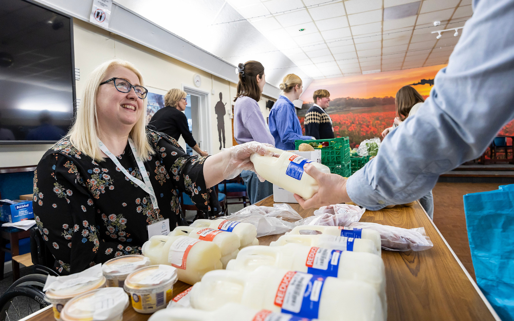 A person collects some milk at SHARE Arborfield