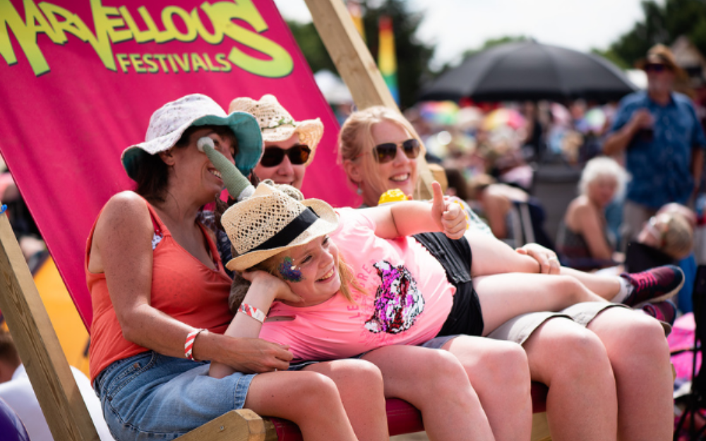 Three adults and a child on a giant deckchair at Marvellous Festival