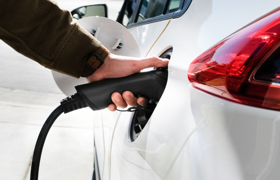 Photograph of a hand plugging a charger into an electric car's charging port