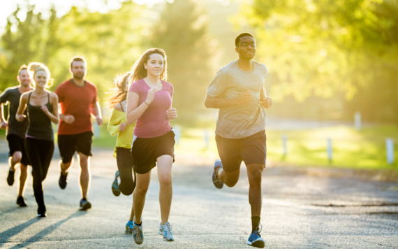 Some men and women running in a park