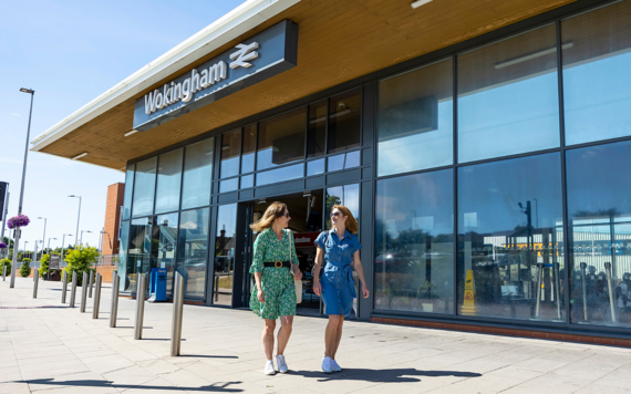 Two women walking past Wokingham train station