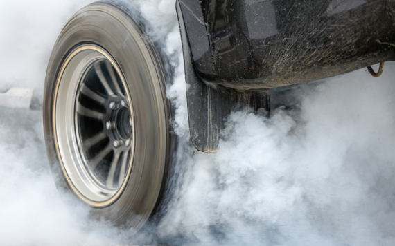 Close up of a car tyre surrounded by smoke