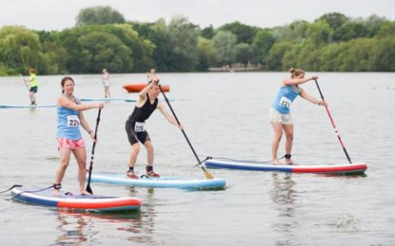 SUPathlon participants paddling-boarding on the lake 