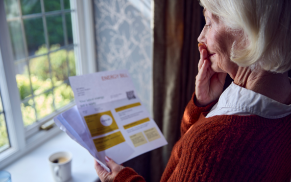 An older woman gasps as she looks at a utility bill