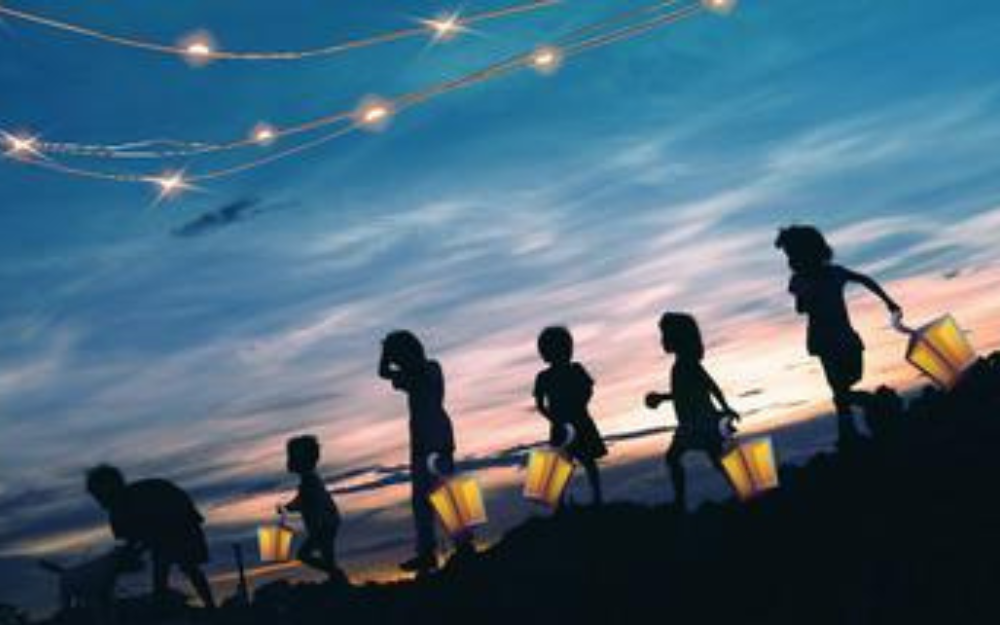 Children carrying lanterns in a line at sunset