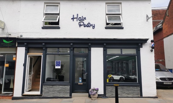 Photograph of a new hair salon with child's seat visible in shopfront window