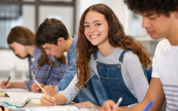 female student writing at a table