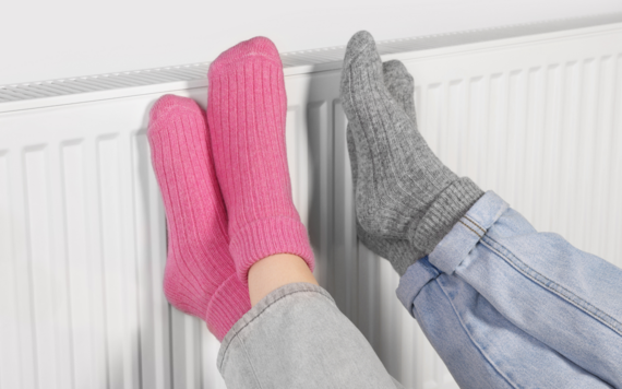 Two pairs of feet on a radiator