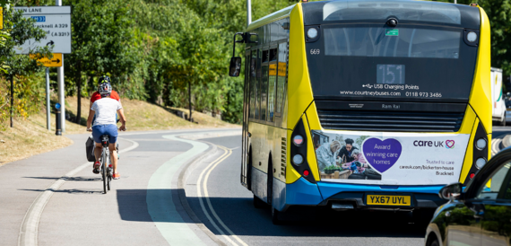 A road in Wokingham Borough with a bus, car and bike taken from behind