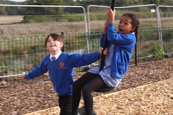 a girl screams excitedly as a boy drags her along the zip line as fast as possible