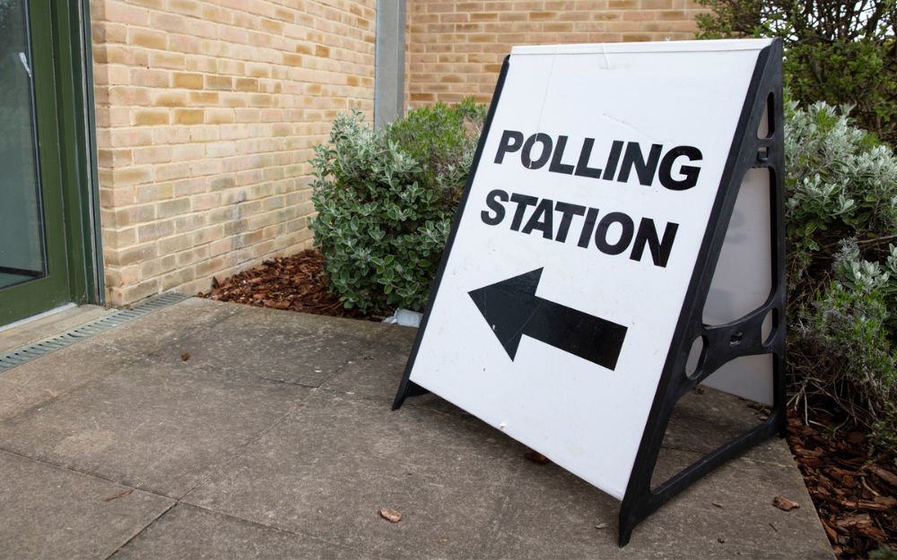 A sign saying polling station pointing to a polling station