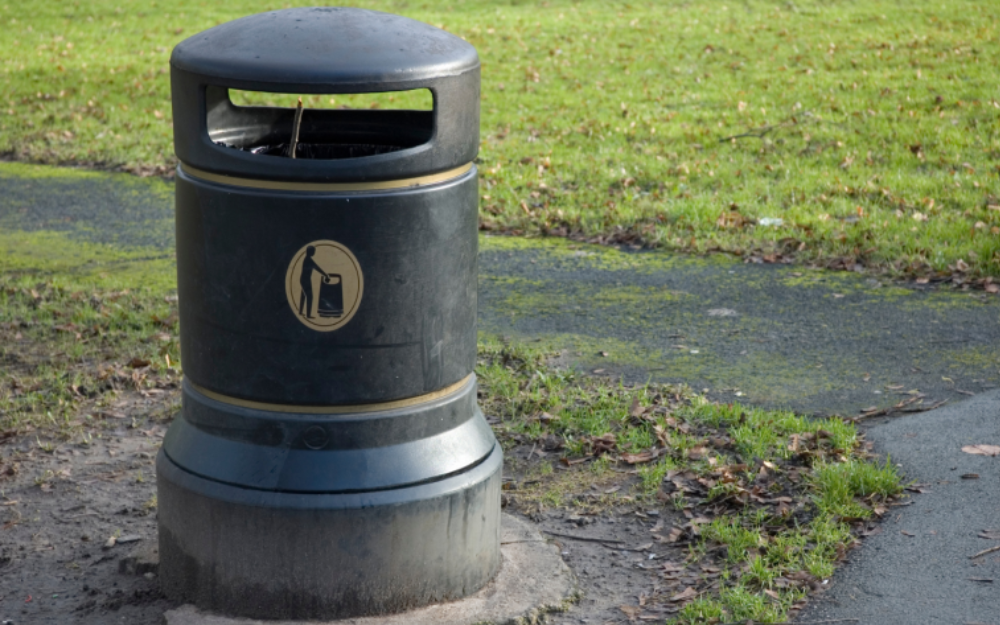 Litter bin in a park next to a path