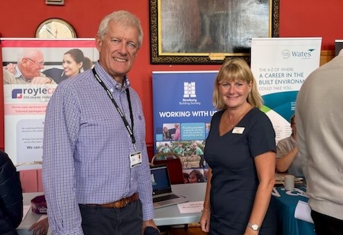 Two people smiling at a stand at the Job Fair in Wokingham Town Hall: Justine Ransom from Newbury Building Society and Councillor David Cornish