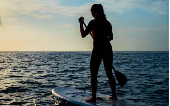 A woman paddling in a lake after dark