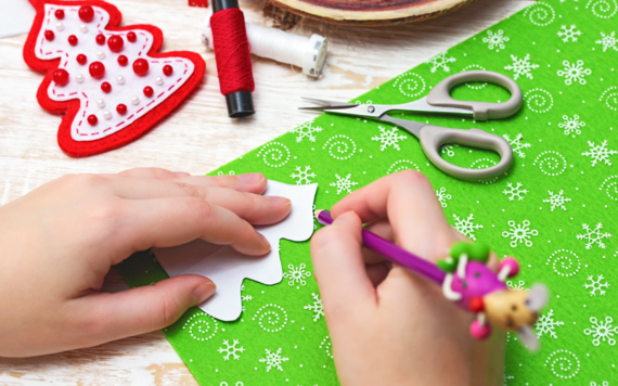 A close-up of a hand doing Christmas crafting