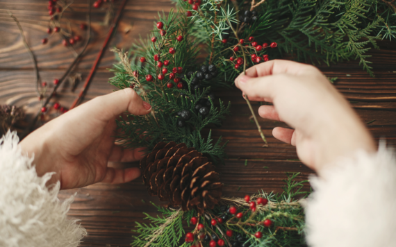 A close-up of a woman's hand making Christmas wreath