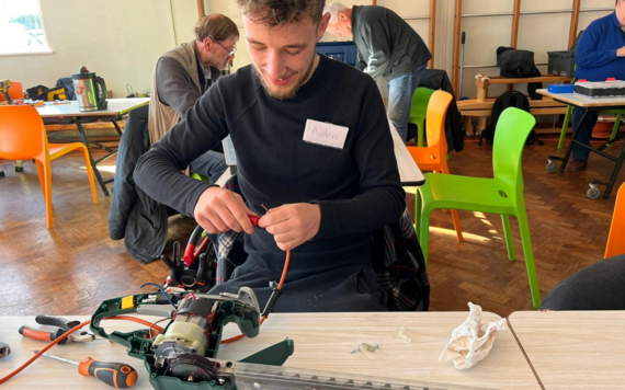 A young man repair a gardening tool