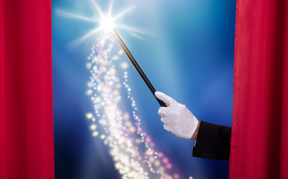 A red curtain drawing open and a hand holding a magic wand and some sparkles