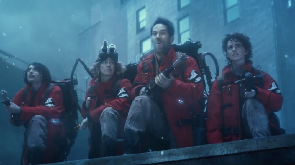 Publicity photo showing four Ghostbusters preparing for battle on the roof of a frozen New York building