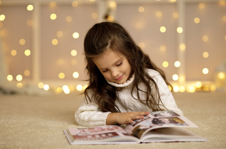 A girl lying on the floor reading a book