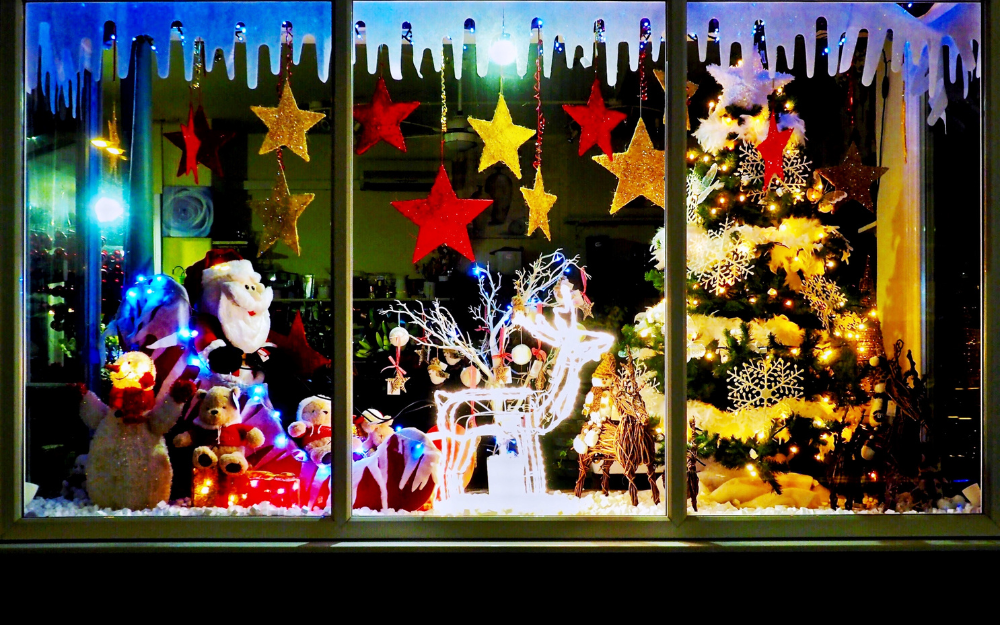 A bright and colourful festive shop window with Christmas tree and figurines