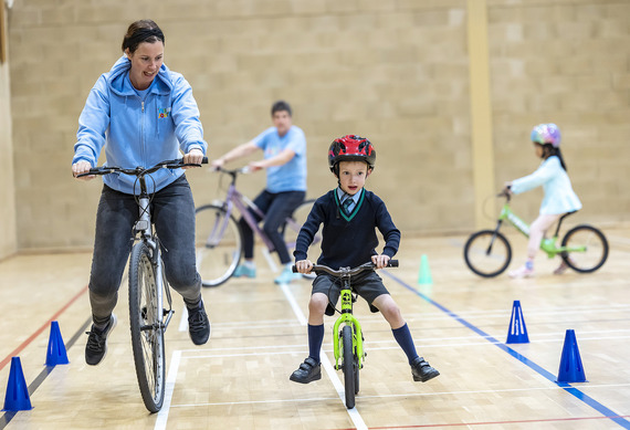 Adult teaching child to ride a bike