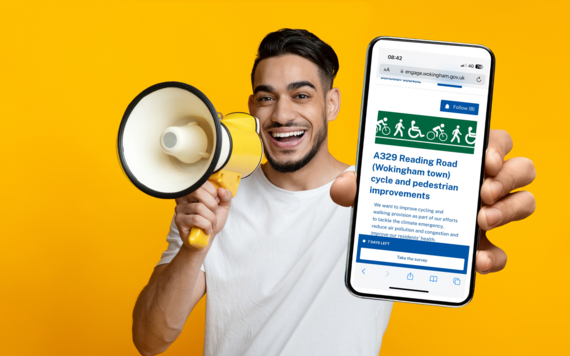 A smiling man holds a megaphone to his mouth and a phone out towards the camera which shows the consultation homepage