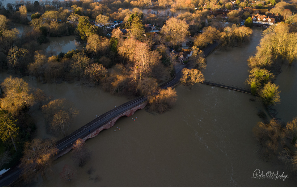 Flooded river Thames at Sonning from overhead, showing flooded fields and rivers close to bursting