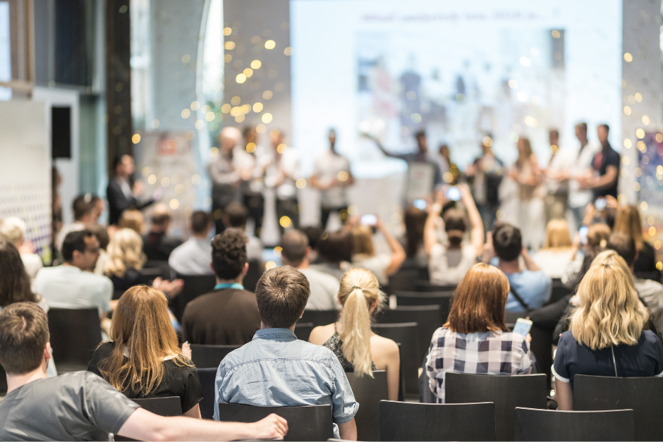 A generic image of people clapping and two glitter bombs going off at an awards ceremony