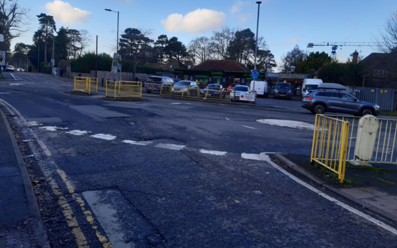 Current view of the junction taken across the two roundabouts showing the garage and shops