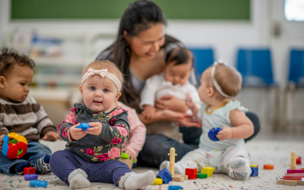 Four toddlers playing on the ground at a childcare setting