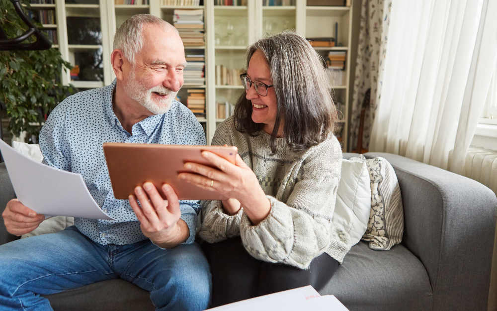 A couple look at their bills on a tablet computer