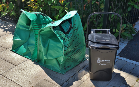Two green recycling bags and a food waste bin at the kerbside