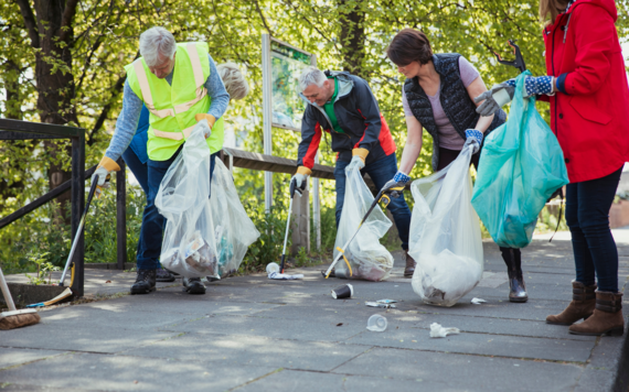 A group of men and women picking litter on the street
