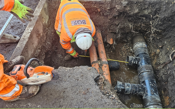 Worker inspecting the dug out pipework