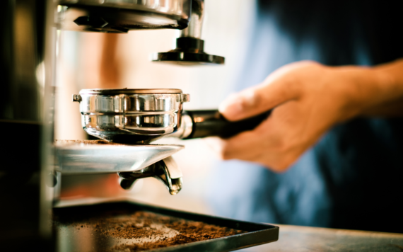A person making a coffee using a barista machine
