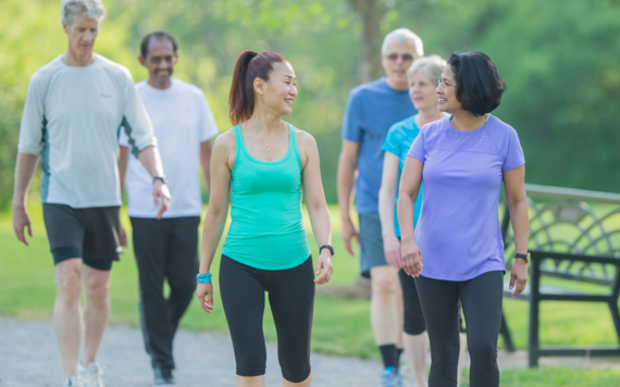 Some men and women walking in a park