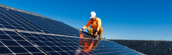 Man fitting solar panels on a roof